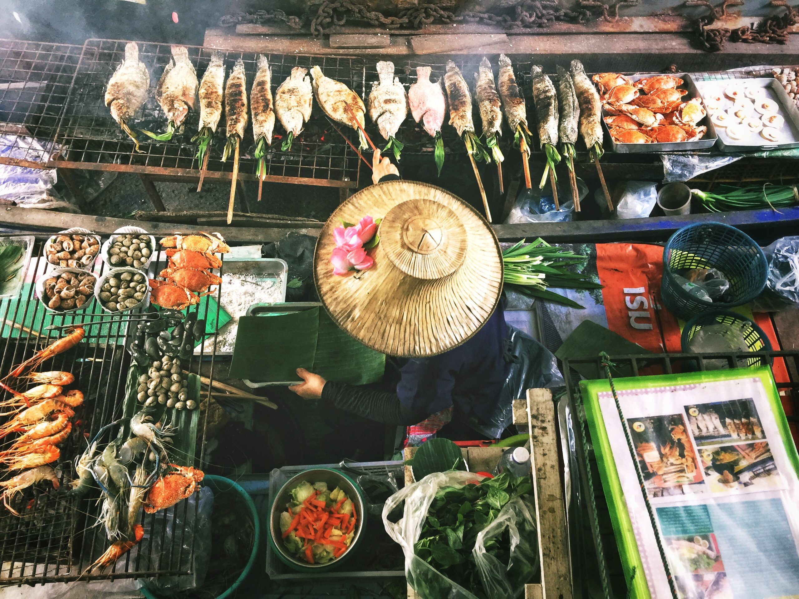 Person cooking on a boat at a floating market in Thailand