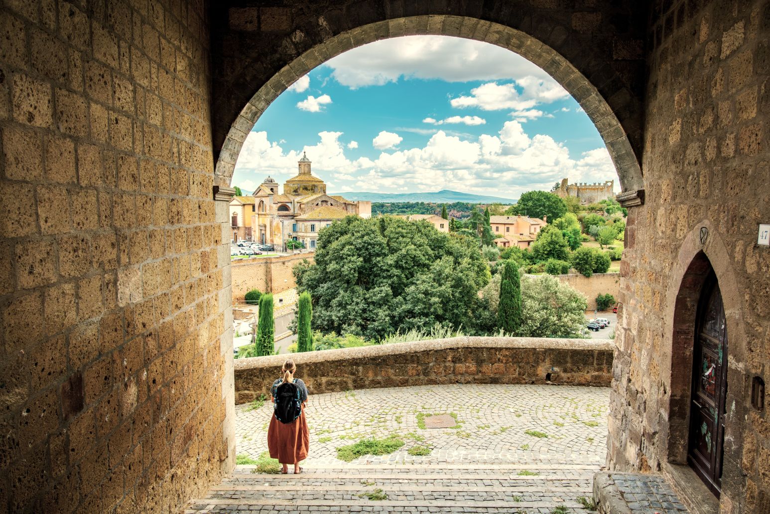 Italy off the beaten path: woman looking out over a scenic landscape amid historical architecture in Viterbo