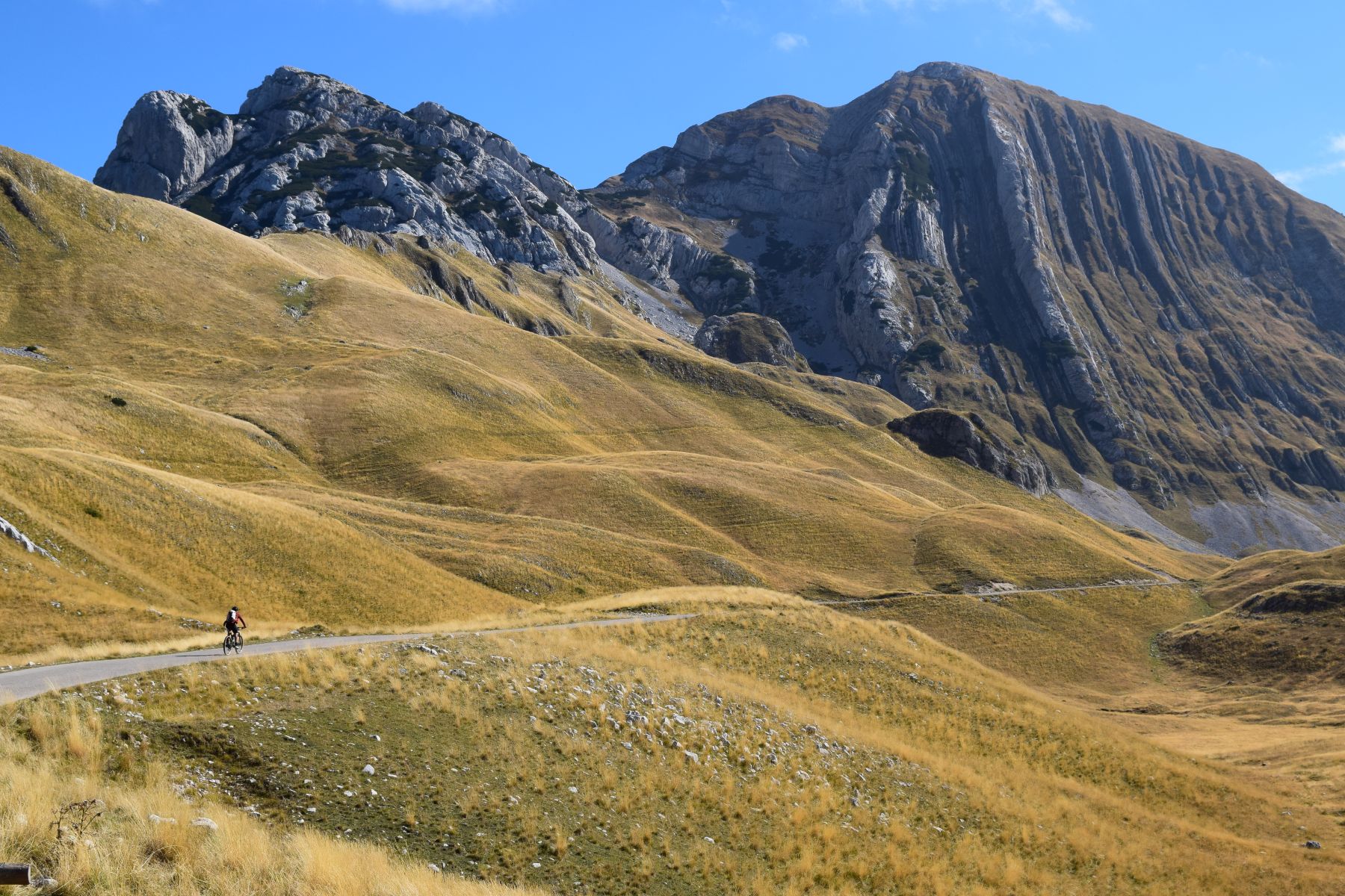 Person cycling through mountain landscape in Montenegro
