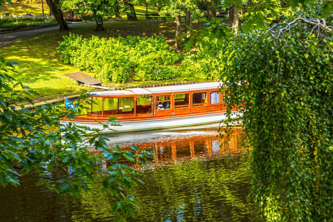 Boat sailing down canal in a park in Riga, Latvia