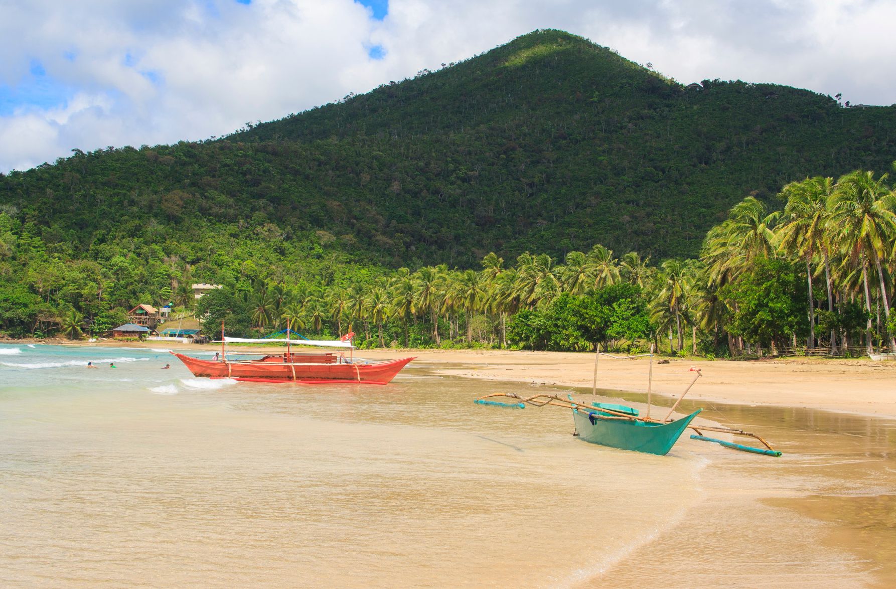 Boats on the shore of Nagtabon beach, Palawan; find out about the weather in the Philippines in December for a winter sun trip