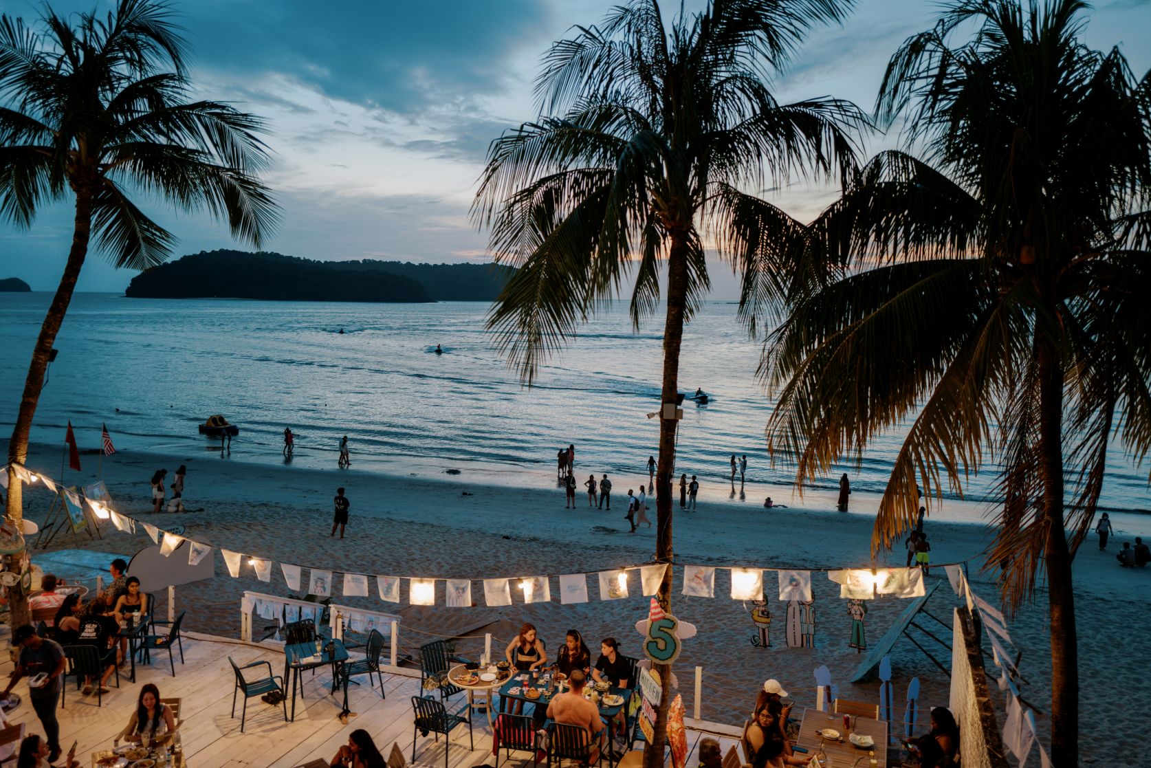 Beachfront restaurant terrace surrounded by palm trees in Malaysia