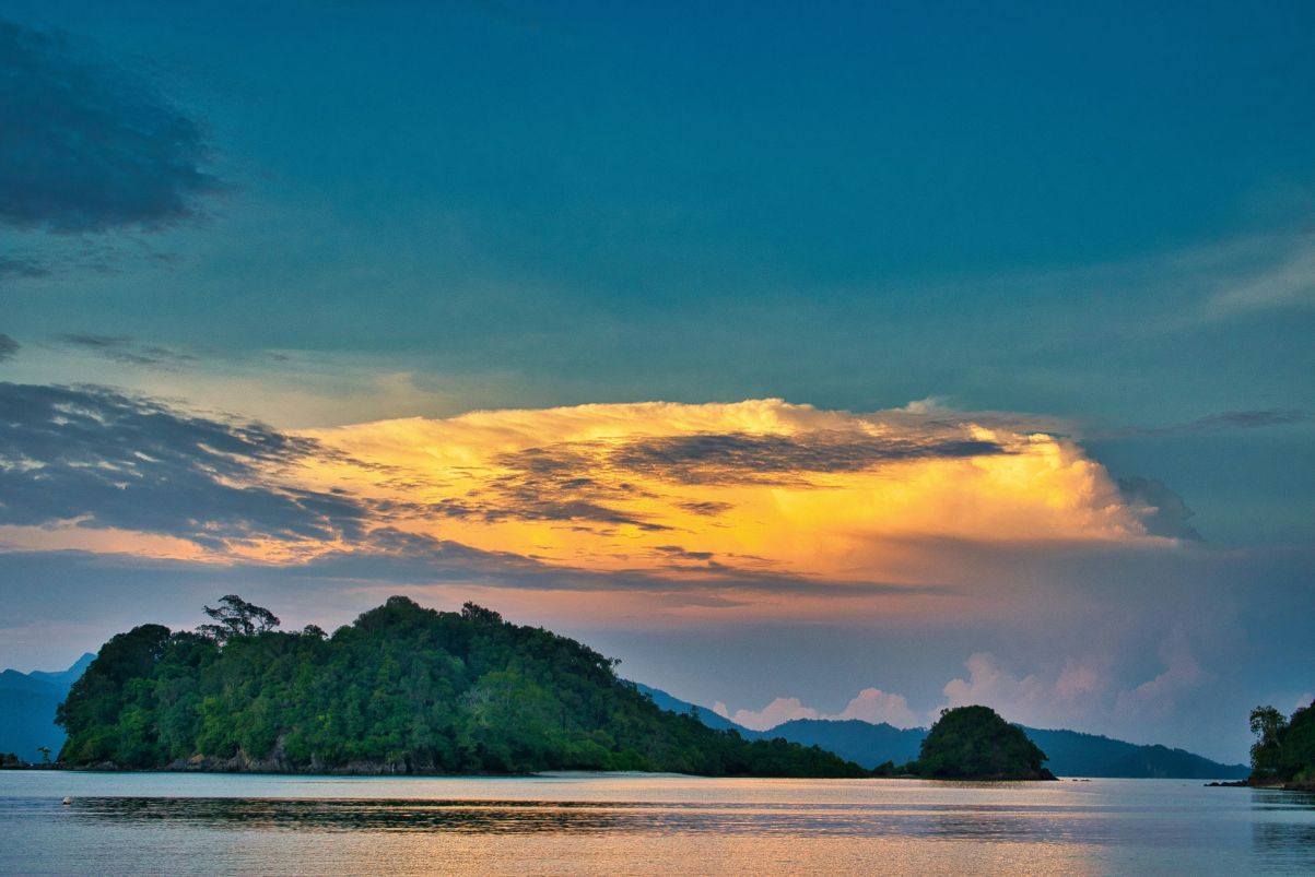 Sunset through the clouds above an island setting in Malaysia