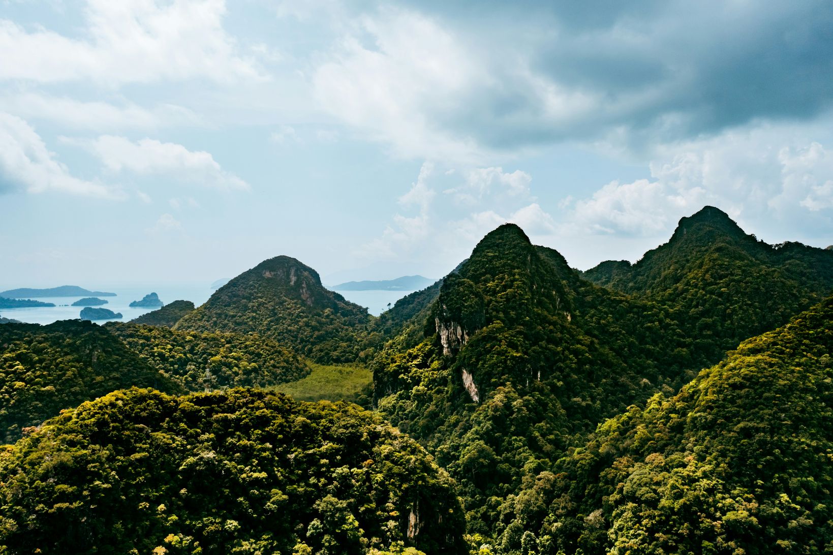 Lush green mountains with seascape in the distance