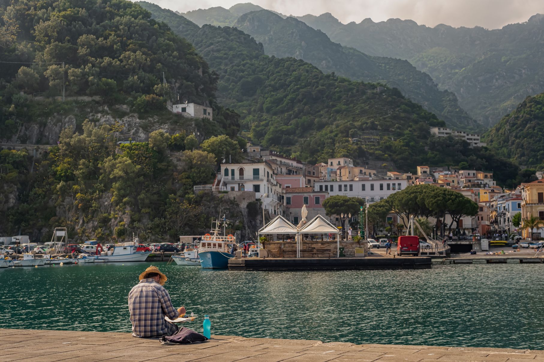 An artist drawing on the water's edge in Cetara, on the Amalfi Coast of Italy