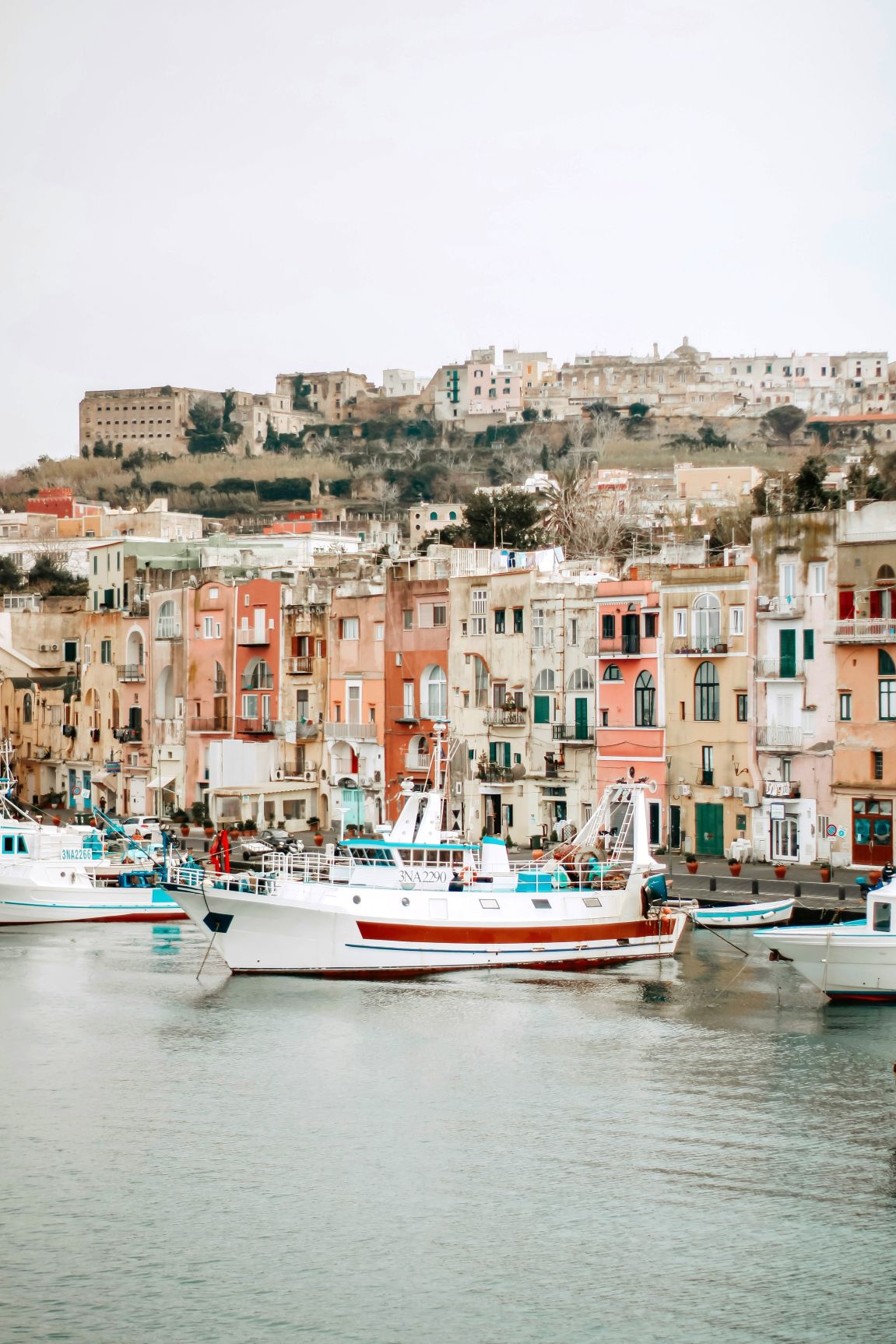 Boats on the water opposite colorful houses in Procida