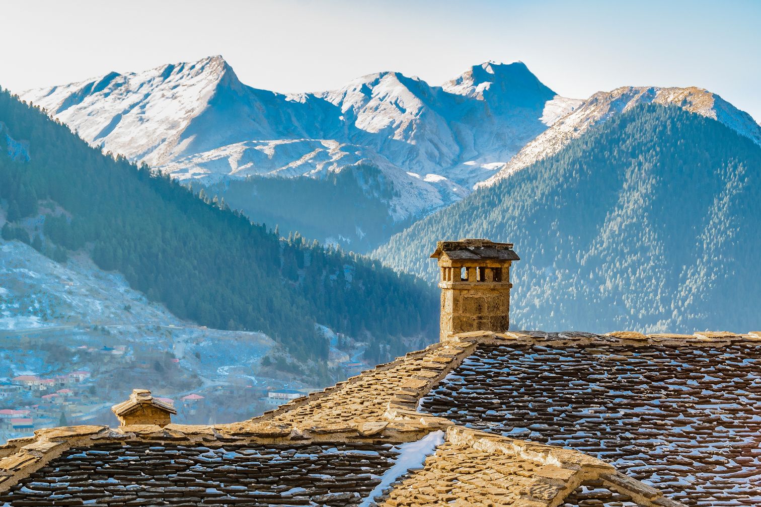 Old rooftop covered in snow in Metsovo, with a mountain backdrop