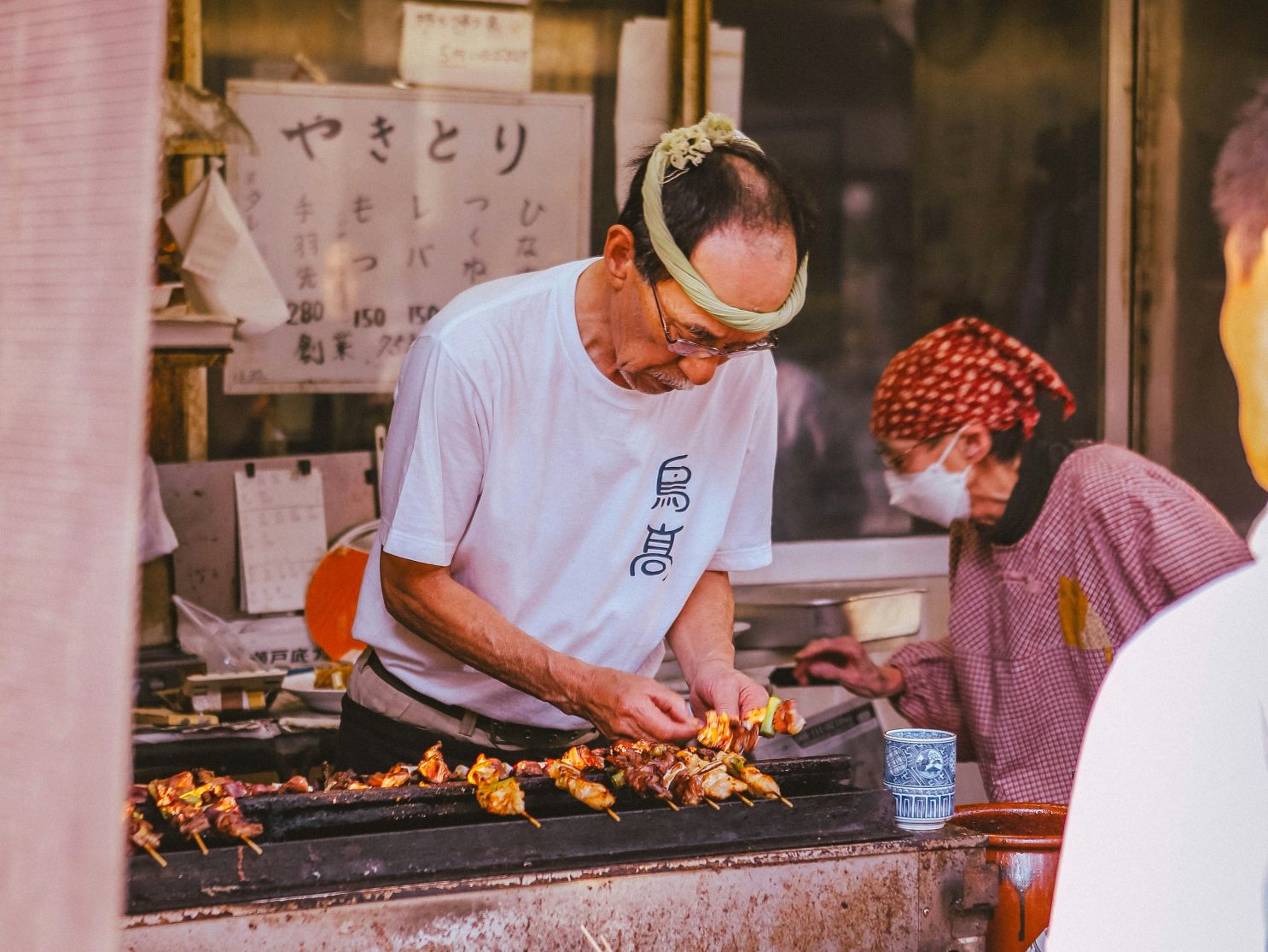 Man preparing yakitori at a food stall in Japan