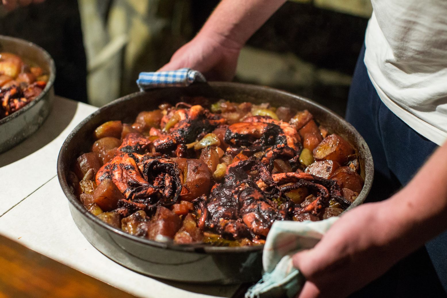 Croatian food: man holding a traditional pot of peka